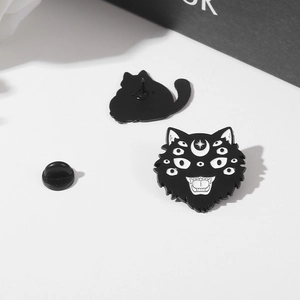 Macro view of a Gothic black enamel cat skull pin with front and back secure rubber clasp