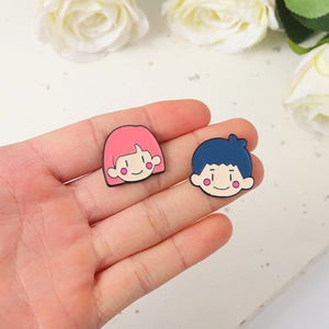 Lot de pins émaillés mignons garçon et fille tenus en main avec fond de rose blanche