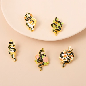 Set of five snake enamel brooches with dagger and floral motifs on a neutral background