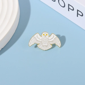 Macro shot of owl enamel brooch showing white gold textures and detailed craftsmanship