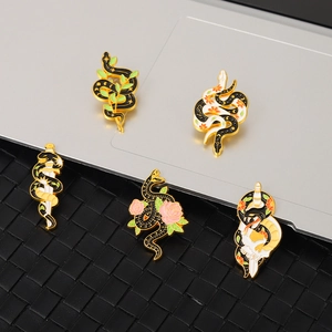 Gothic snake and sword enamel pins set with floral details in gold plated metal finish
