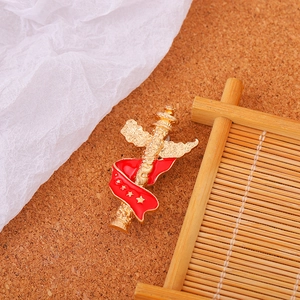 Exquisite gold Huabiao metal brooch with red ribbon and stars on cork background