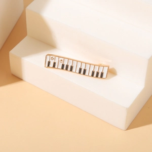 Elegant piano keyboard enamel brooch with cat paw patterns on a gold plated metal base