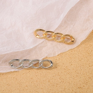 Minimalist twisted metal safety pin brooches in polished gold and silver finishes