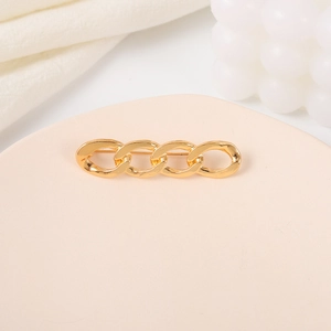 Detail of a minimalist gold twist brooch with champagne gold chain link design on display