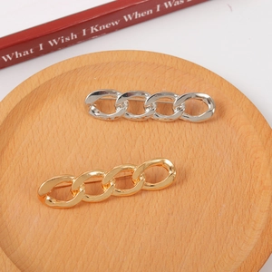 Minimalist gold and silver metal chain hairpins displayed on a circular wooden tray