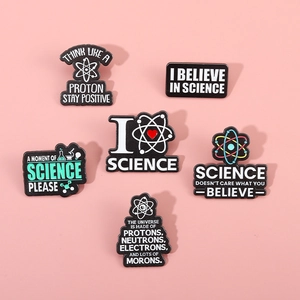 Set of six black enamel science pins with atom designs and funny laboratory slogans