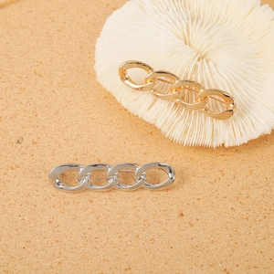 Close-up of gold and silver chunky chain brooches with a polished metallic finish