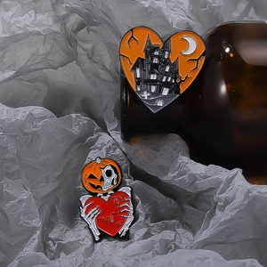 Detail of Halloween enamel pins with orange heart castle and pumpkin skull designs