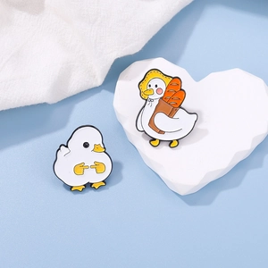 Close-up of cute enamel duck pins with shy expression and baguette bag details
