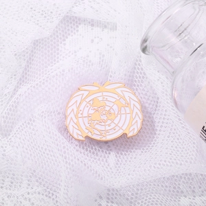 Golden UN emblem pin with white enamel world map and wheat design on lace fabric