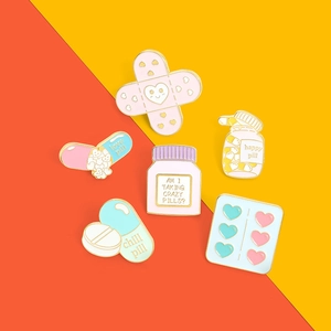 Detailed view of 6-piece medicine themed enamel pins including heart band-aids and pill bottles