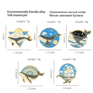 Set of 5 cartoon whale enamel pins featuring mountains, stars and ocean waves designs