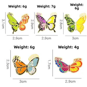 Lot de pin's papillon en émail coloré avec pronoms et dimensions sur fond blanc net