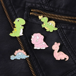 Close-up of colorful cartoon dinosaur enamel pins on a black textured leather jacket