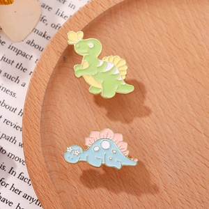Detailed macro view of colorful cartoon dinosaur enamel brooches on a wooden display tray