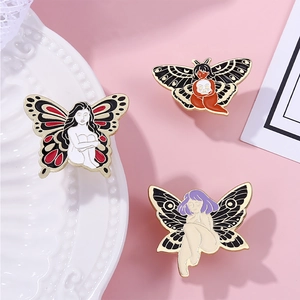 Three colorful butterfly girl enamel pins on a white ceramic tray with pink background