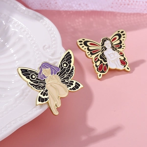 Detailed close-up of two enamel butterfly girl brooches on a white textured plate