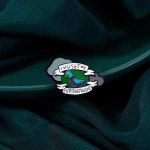 Broche en émail pigeon bleu rigolo avec slogan sur fond en soie verte