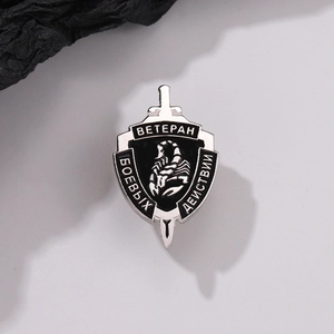 Close-up of tactical alloy shield brooch with black scorpion and sword relief