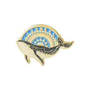 Detailed macro view of whale enamel brooch with golden sun, moon and starry sea waves