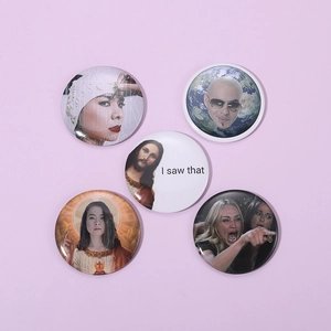 Close-up of five round tin badges featuring Mitski, Pitbull, and famous internet memes