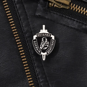 Punk shield-shaped scorpion badge with silver metal and black enamel on leather jacket