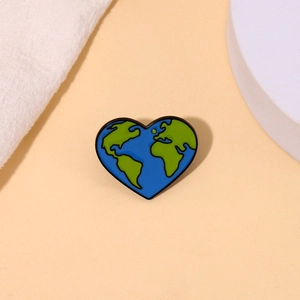 Spilla smaltata a forma di cuore con mappa del mondo su sfondo beige e minimalista