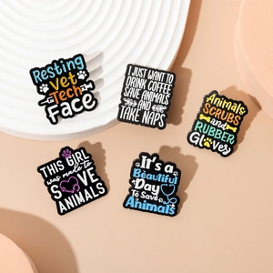 Five-piece veterinary enamel pin set with animal welfare themes on a decorative tray
