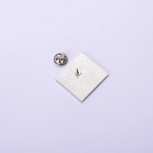 Back view of silver alloy badge showing textured surface with pin and butterfly clutch