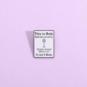 Macro detail of This is Bob enamel pin featuring stick man on white rectangle metal badge