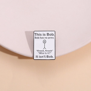 Rectangle enamel pin featuring Bob doodle and funny text on a pink display stand