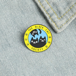 The Black Cat Society enamel pin badge featuring three black cats on blue denim fabric