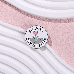 Minimalist round floral brooch with SURVIVE OUT OF SPITE text in white enamel