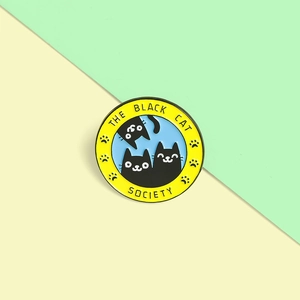 Detailed close-up of The Black Cat Society round enamel pin with cute cartoon cats