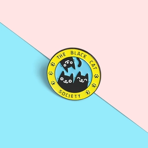 Detail showing The Black Cat Society enamel pin with blue background and yellow border