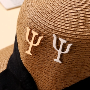 Macro detail of gold and silver Psi symbol pins on a woven hat with black ribbon