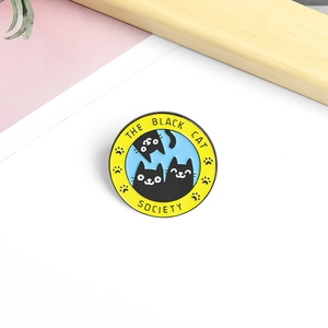 Round enamel pin badge featuring cartoon black cats with The Black Cat Society text
