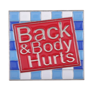 Square enamel pin badge featuring red Back & Body Hurts slogan with plaid border design