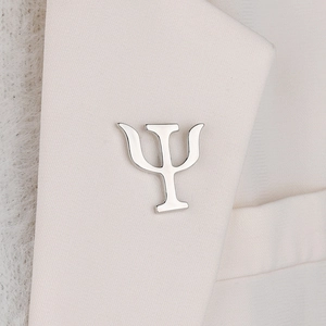 Macro detail of silver Psi symbol brooch on white suit lapel for psychology professionals