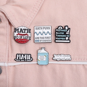 Detail of funny math enamel pins with function curves on pink denim jacket