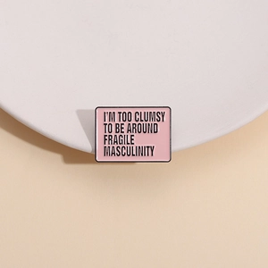 Pink enamel brooch with 'I'M TOO CLUMSY TO BE AROUND FRAGILE MASCULINITY' slogan