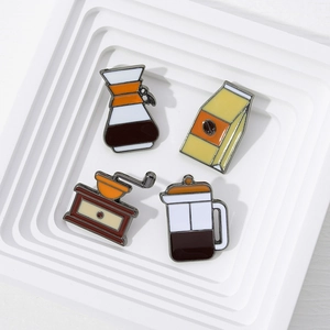 Détail de quatre épingles en émail café avec moulin et bouilloire sur présentoir