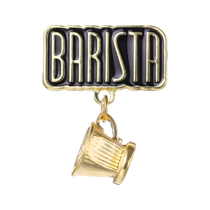 Detailed macro view of a golden Barista brooch with a hanging coffee cup pendant charm