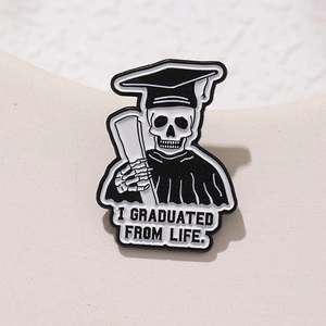 Skull graduate enamel pin in black and white with I Graduated From Life quote