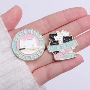 Cute enamel cat pins set with funny English slogans on a light blue and pink background