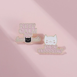 Macro shot of cute enamel cat pins with Keep Calm and I'm So Purrrfect lettering