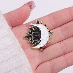 Celestial sun and moon enamel pin badge with anthropomorphic faces in black and white finish