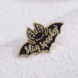 Épinglette chauve-souris en émail noir et or avec l'inscription artistique Stay Spooky