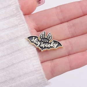 Broche chauve-souris gothique en émail noir avec texte Stay Spooky sur blanc